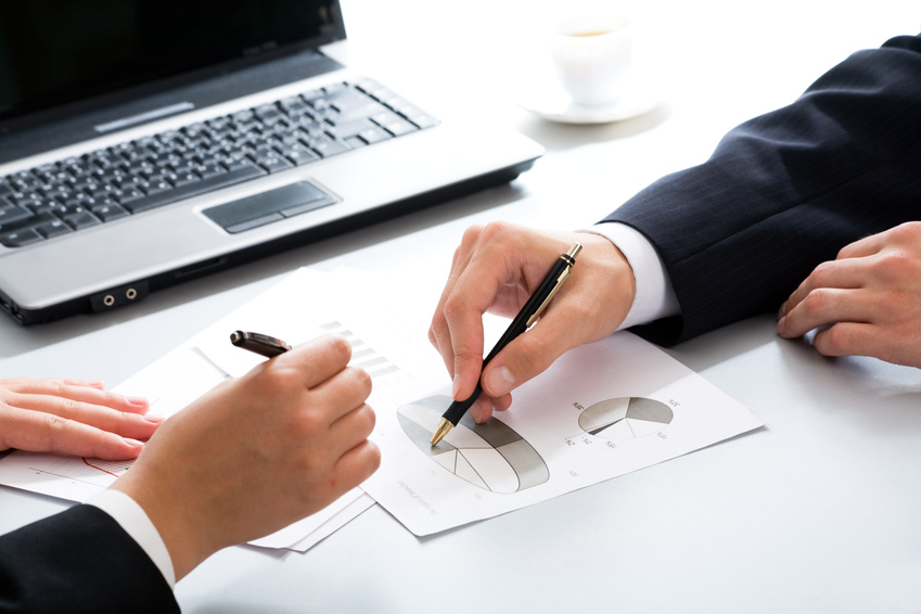 Close-up of business partners hands over papers discussing them